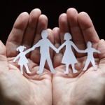 Hands holding paper cut-outs of people