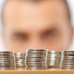 Man looking at piles of coins