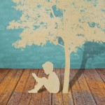 Child sitting under a tree