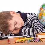 child sleeping on school books