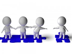 Cartoon people standing on jigsaw pieces and reaching out to pull another into the fold