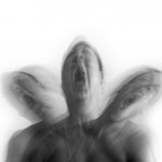 Blurry black and white picture of three heads screaming