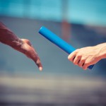 A baton being handed between athletes