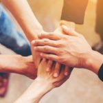 Concept of teamwork: Close-Up of hands business team showing unity with putting their hands together.