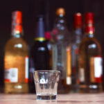 Empty,Small,Shots,Glass,In,Front,Of,Multiple,Blurry,Different