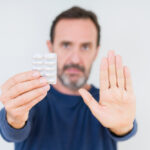 Senior,Man,Holding,Pharmaceutical,Pills,Over,Isolated,Background,With,Open