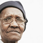 Closeup,Portrait,Of,Elderly,Woman,Wearing,Glasses,Over,White,Background