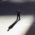 Lone,Man,In,Empty,Space,With,Dramatic,Shadow.,Looking,Down