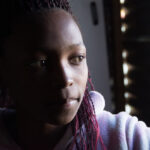 LANGA TOWNSHIP, SOUTH AFRICA - JULY 12, 2015 - A young girl poses for a photograph at her home in Langa, South Africa, a township located on the outskirts of Cape Town.