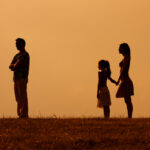 Silhouette of a angry husband turning back while his wife and daughter are looking at him.Angry father turning back on his family