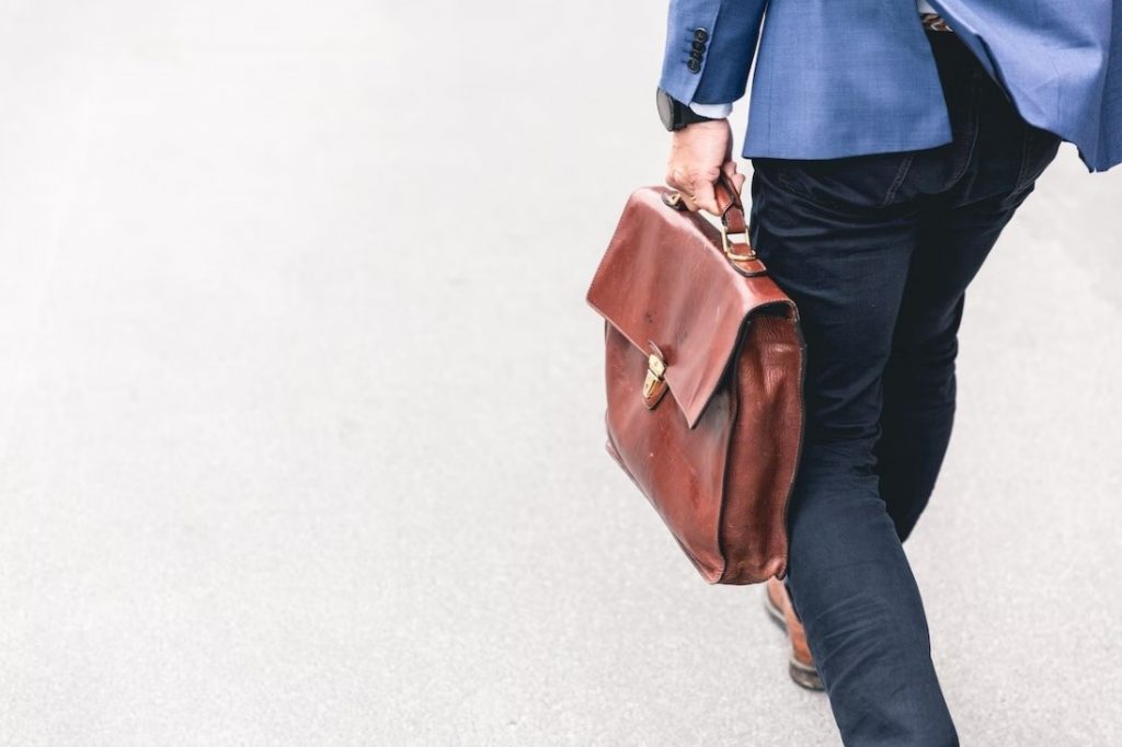 person carrying briefcase which is brown