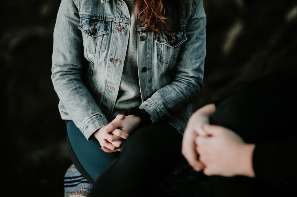 person sitting with crossed legs in denim outfit