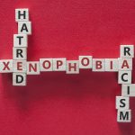 Xenophobia, hatred and racism words written with blocks on red background. Social issues concept