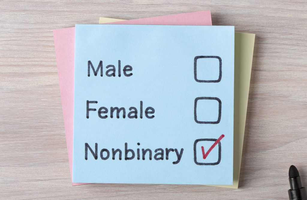 A post it note with a tick next to non-binary on a list, and empty tick boxes next to male and female.