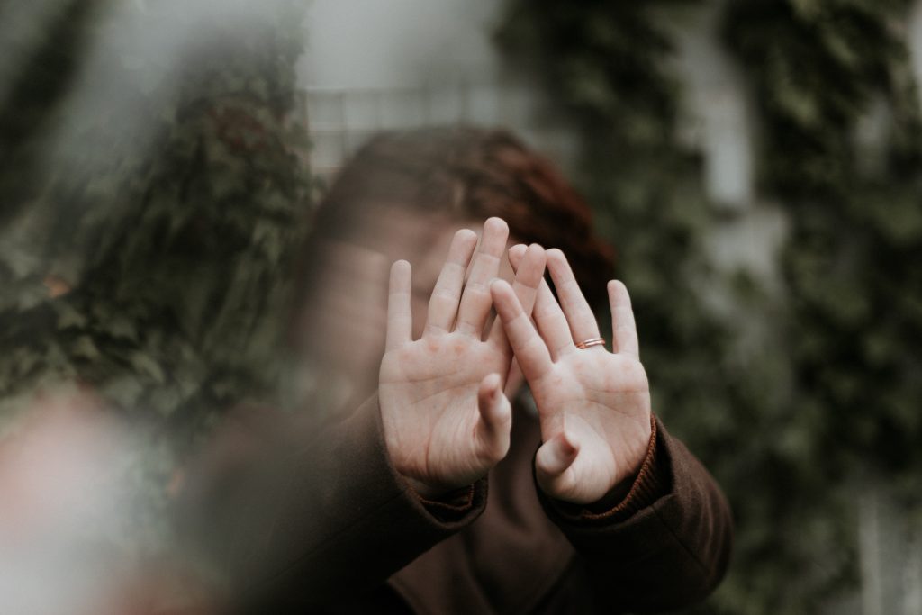 a girl with brunette hair reaches her hands out towards the camera