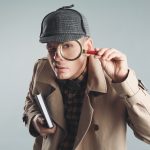 Male,Detective,Looking,Through,Magnifying,Glass,On,Grey,Background