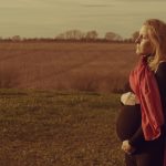 Lonely,Pregnant,Woman,Standing,In,A,Field,Worried,About,Her