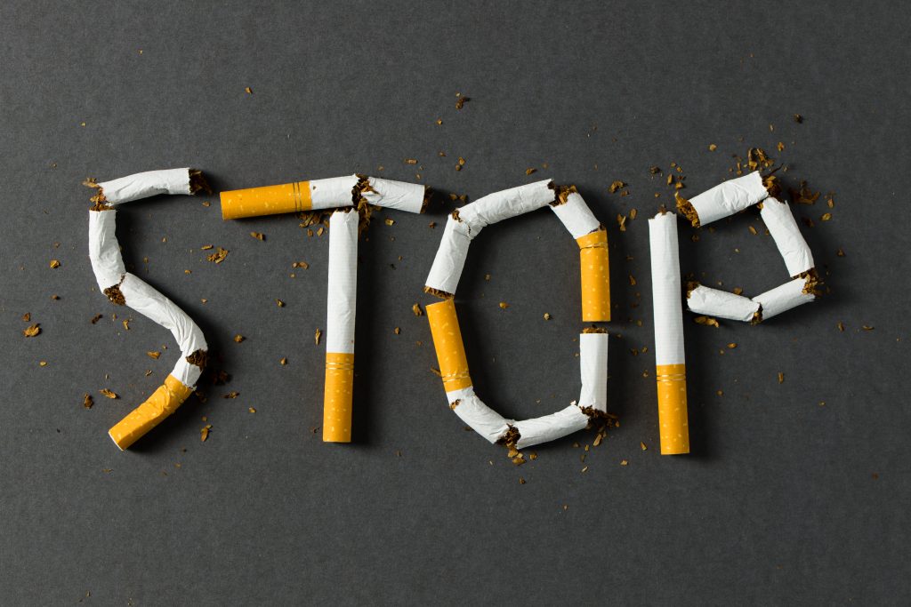 cigarattes with orange butts spell out the word STOP in capital letters