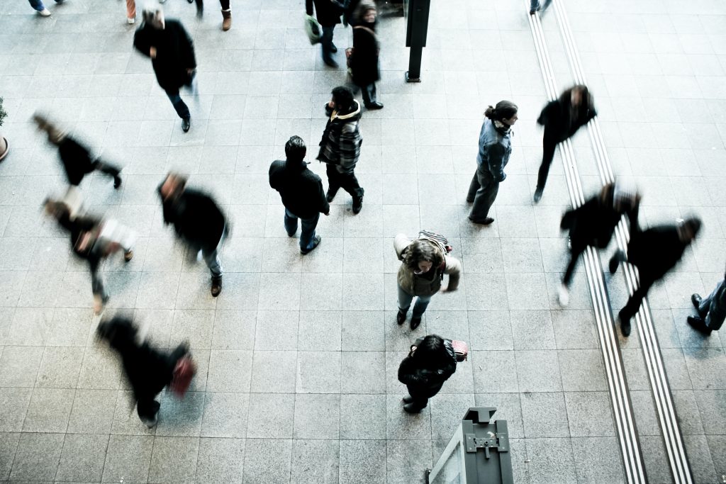 a view of people walking from above, some people a blurry and others are still and in focus