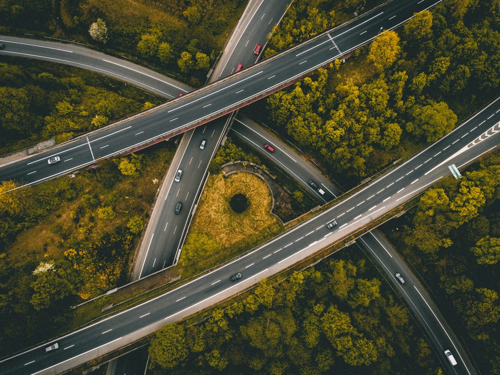 Four road cross over each other, and are surrounded by green trees