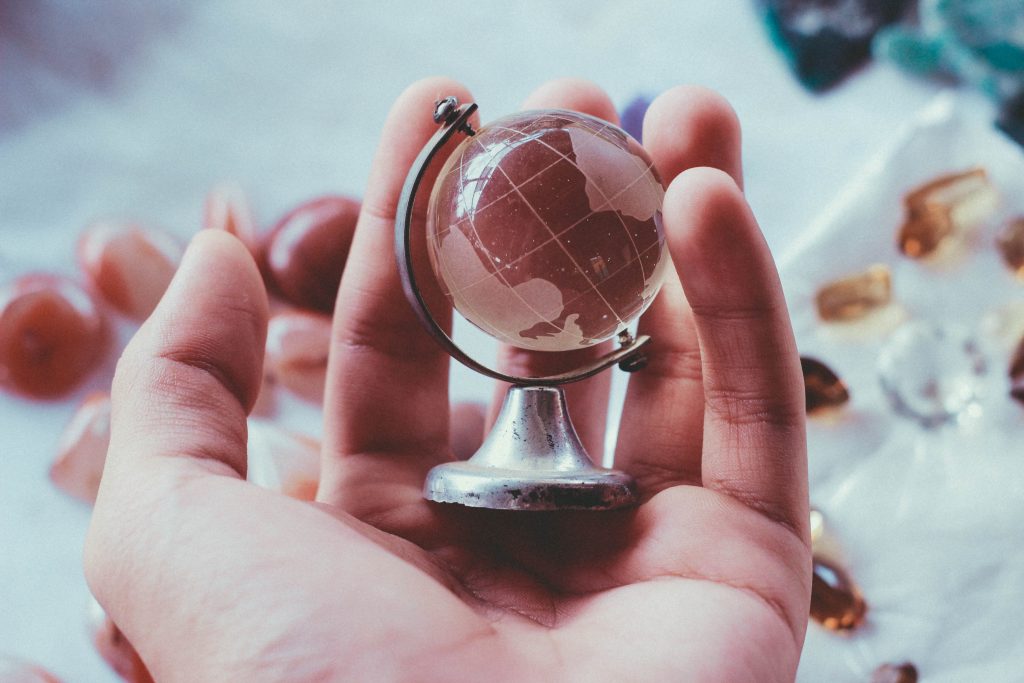 a glass globe is held in a white hand