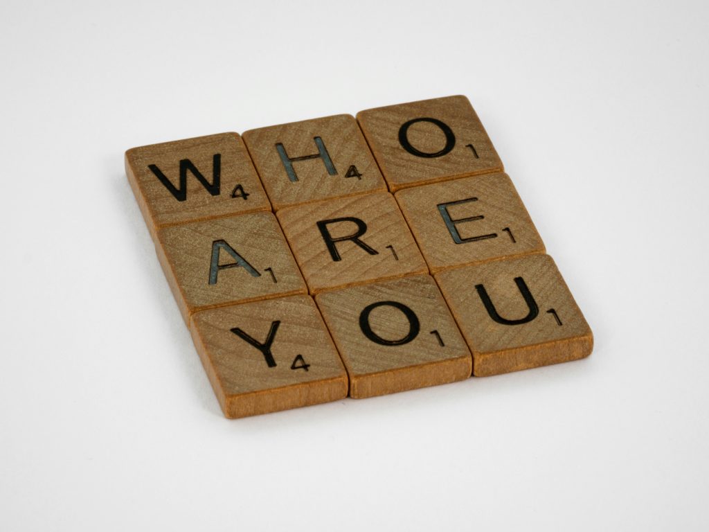 Scrabble chips spell out "who are you"