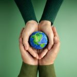 World Earth Day Concept. Green Energy, ESG, Renewable and Sustainable Resources. Environmental Care. Hands of People  Embracing a Handmade Globe. Protecting Planet Together. Top View