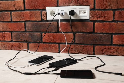 Smartphones,Charging,With,Cables,On,Floor,Indoors