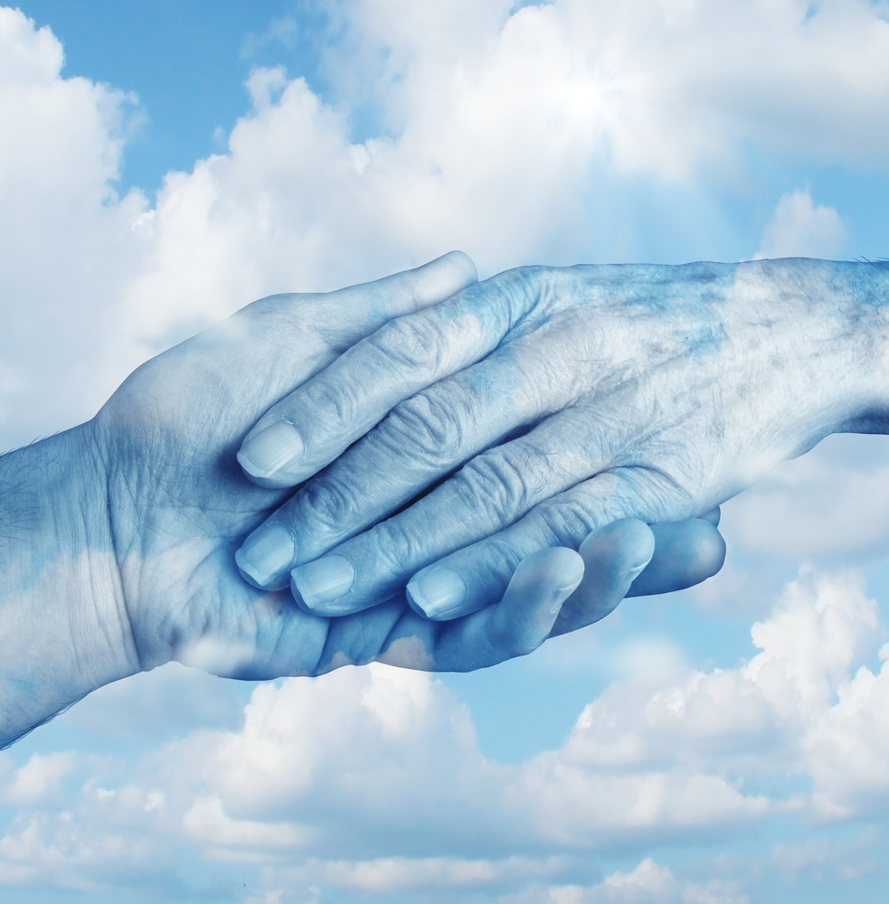 Hands holding across clouds