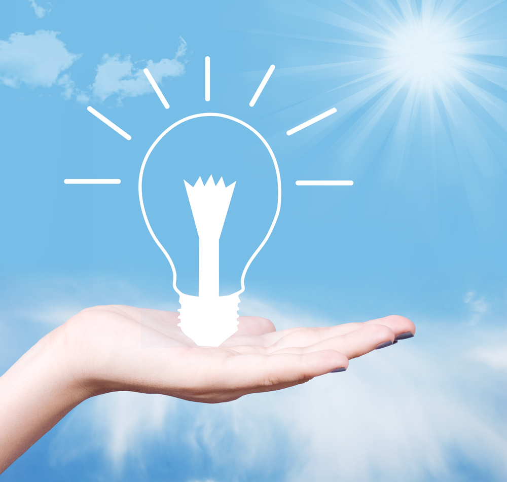 Hand holding a glowing lightbulb
