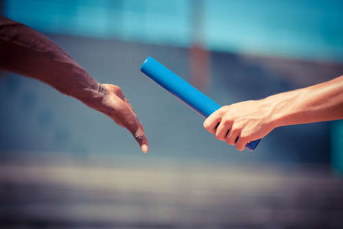 A baton being handed between athletes