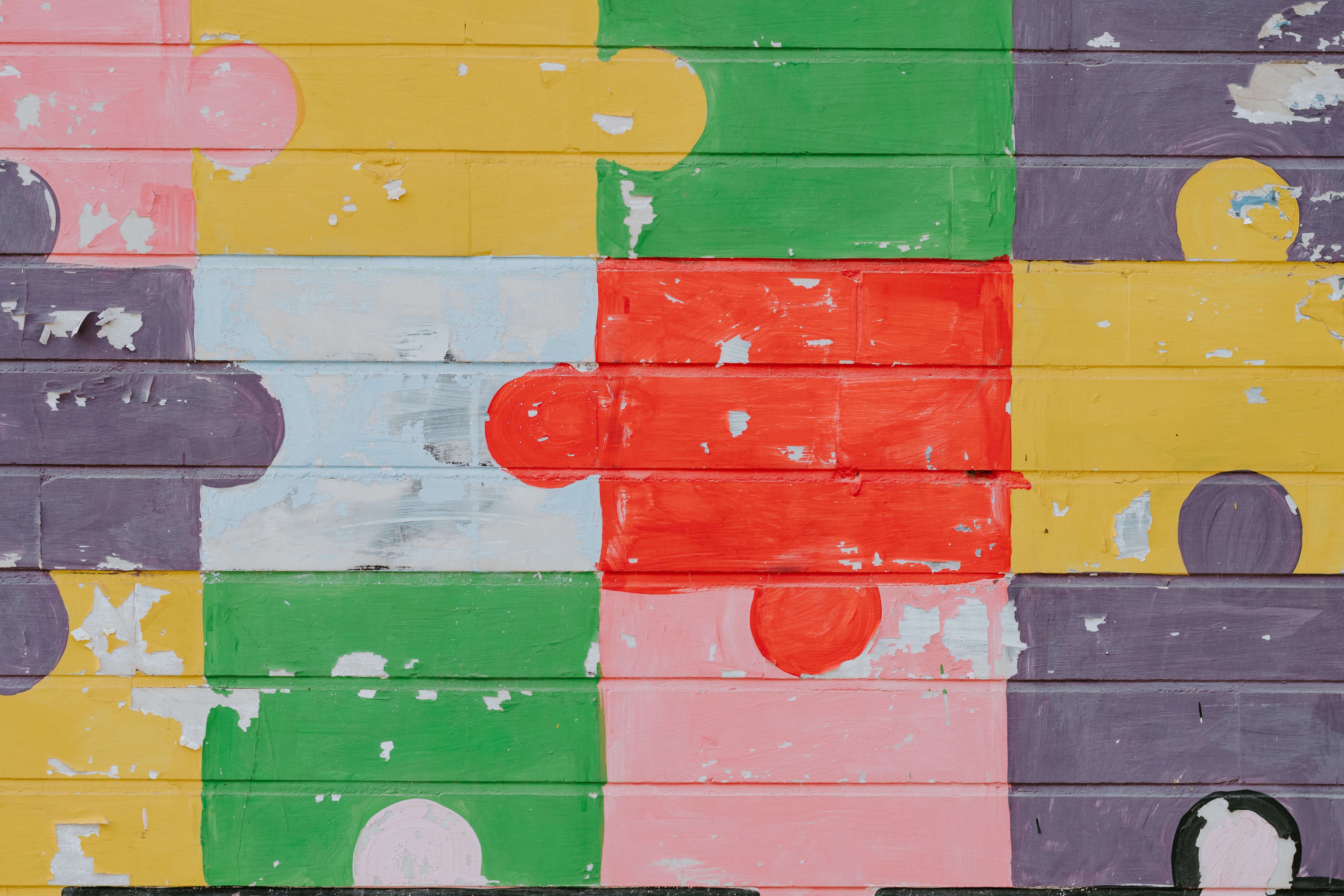 multi coloured puzzle pieces painted onto a wall