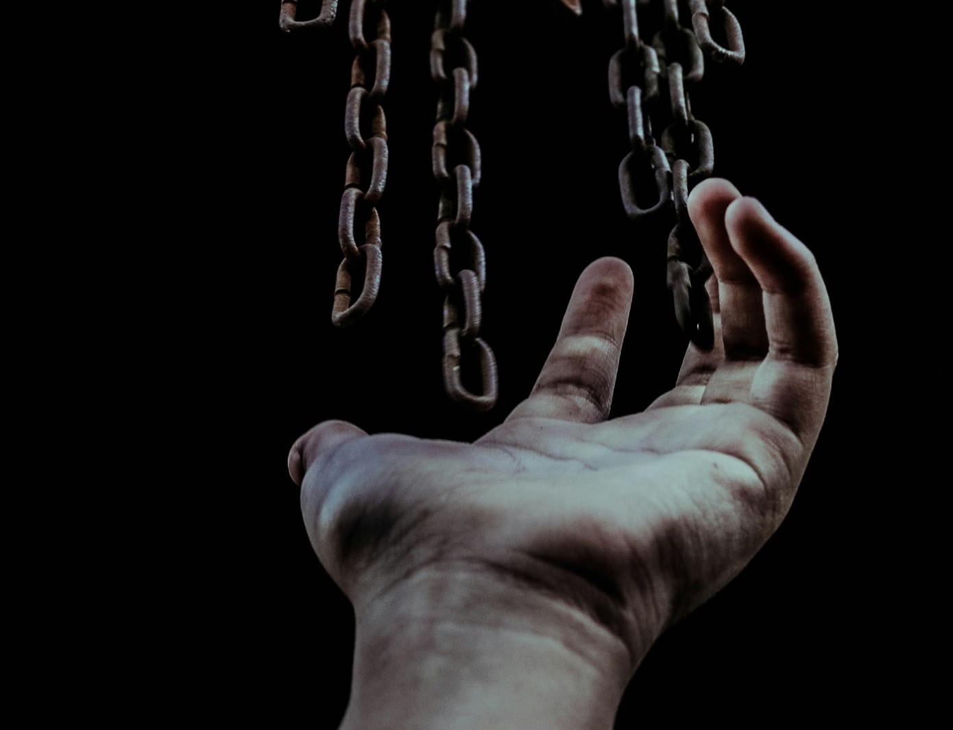 A hand below metal chains