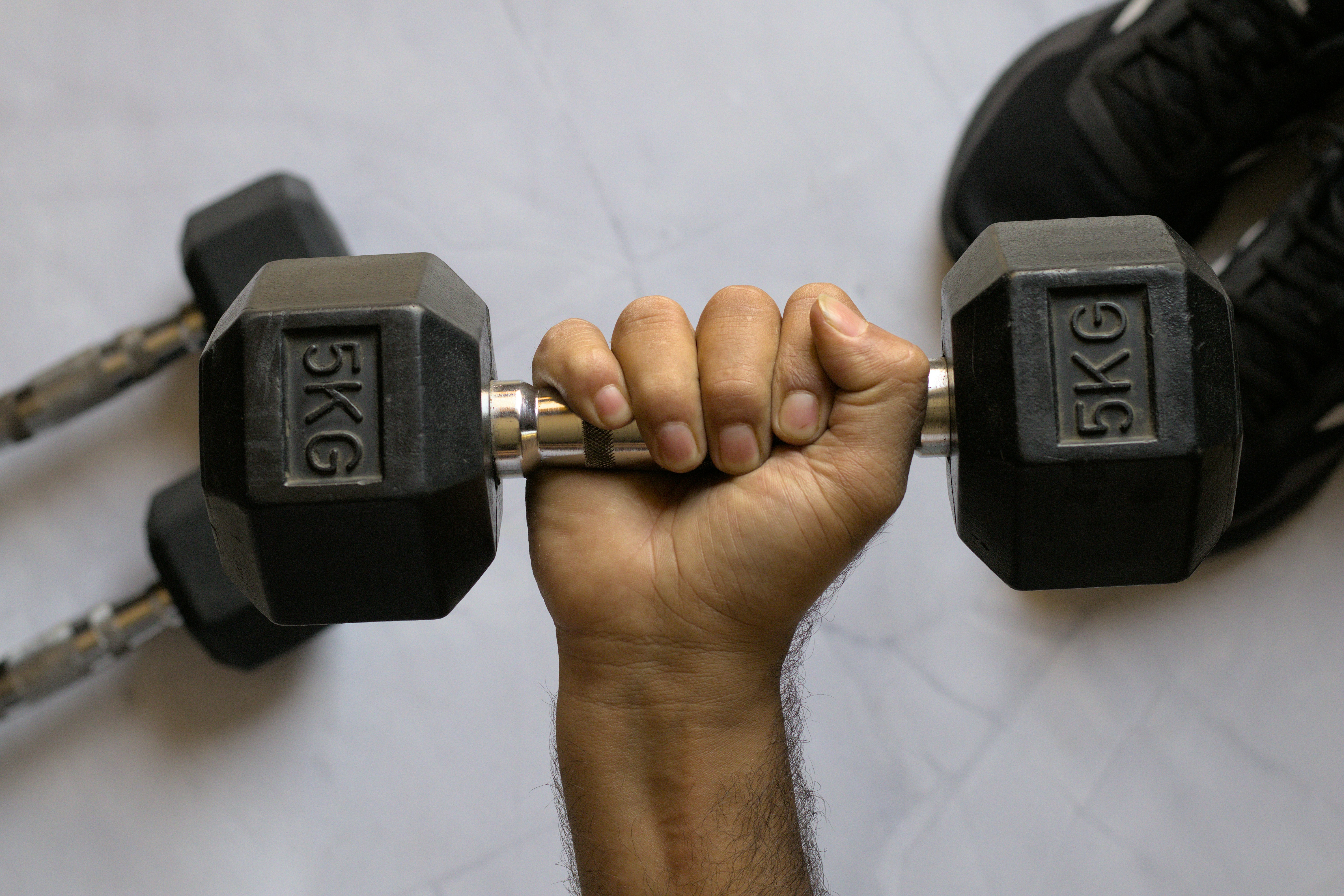 A hand holds up a dumbbell weight