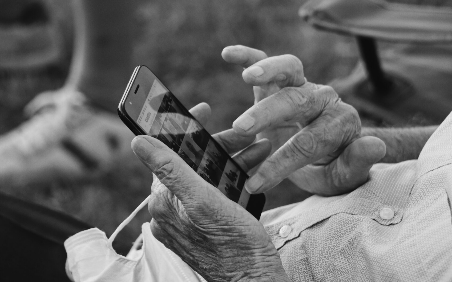 An older person holding a phone with only their hands visible