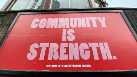 A sign reads community is strength