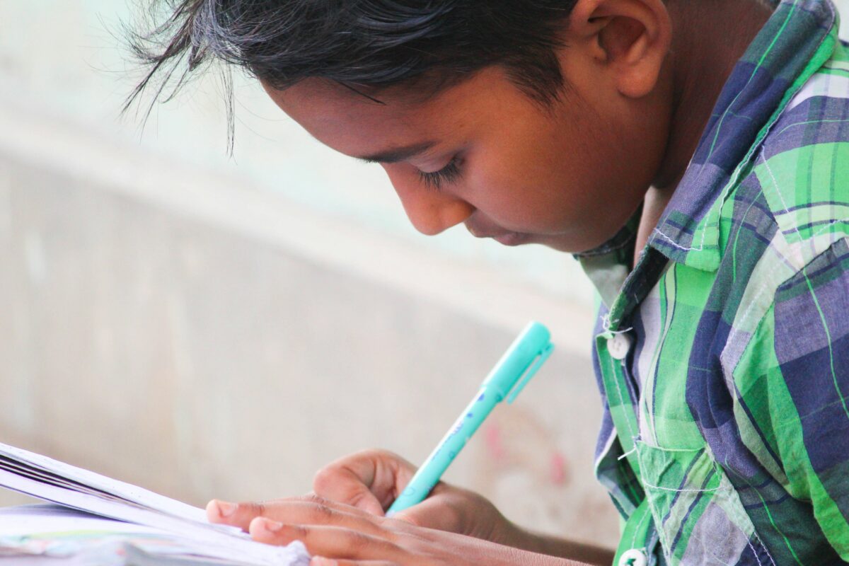 A young boy writing in a notebook