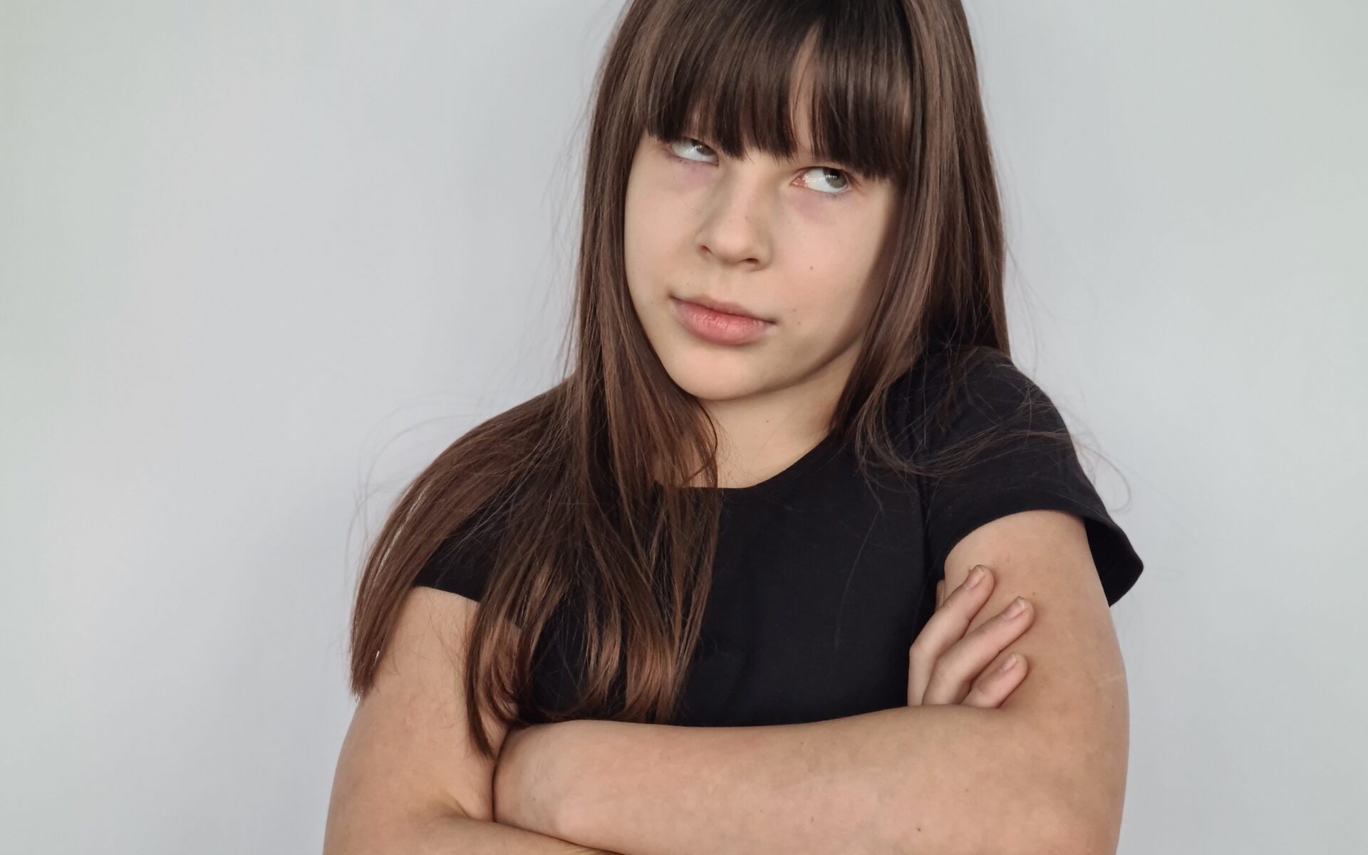 Young girl child teenager rolls eyes pretending. Emotions are tired and discontent