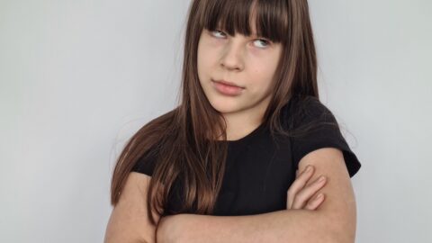 Young girl child teenager rolls eyes pretending. Emotions are tired and discontent